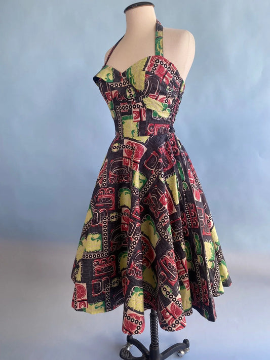 Vintage-inspired halter dress with bold geometric print, flared skirt, and Hollywood glamour style
