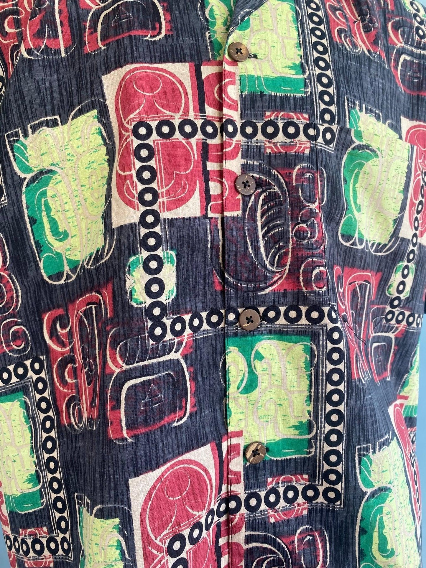 Vintage-inspired abstract print shirt with bold red, green, and navy patterns and button front